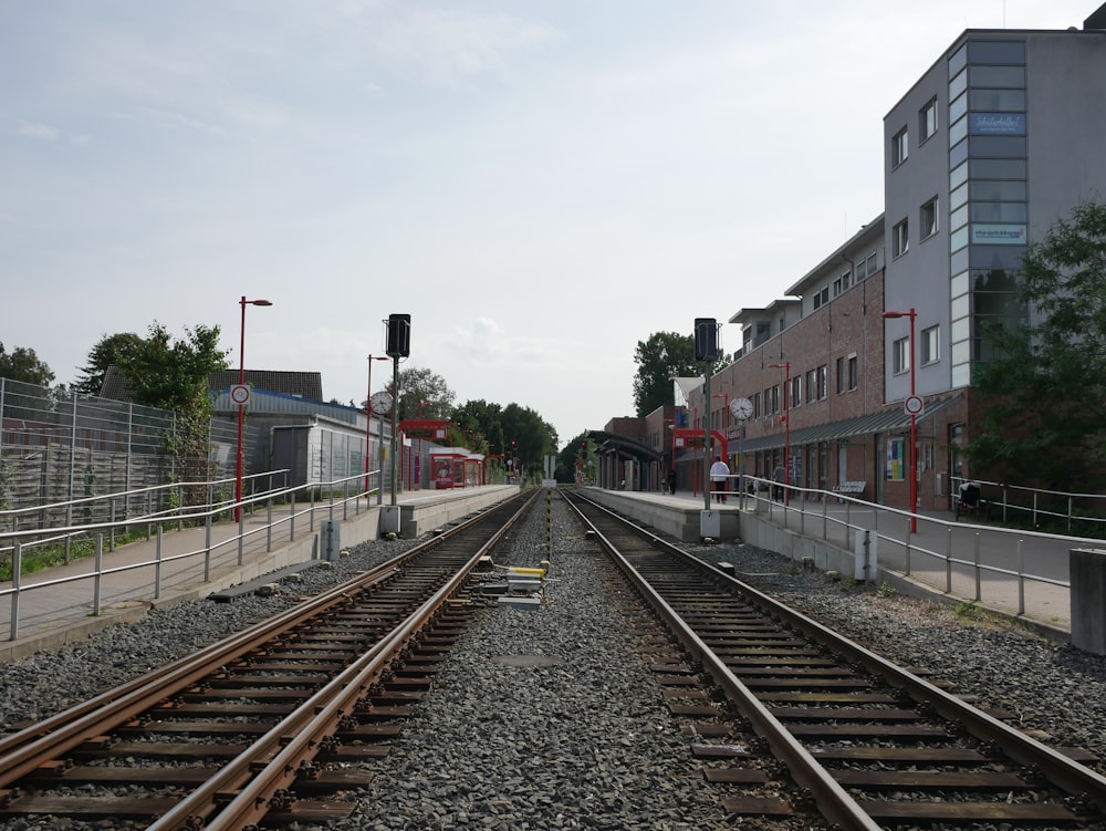 red and white train rail near red and white concrete building during daytime