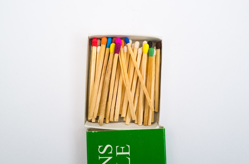 bâtons en bois brun sur livre vert et blanc