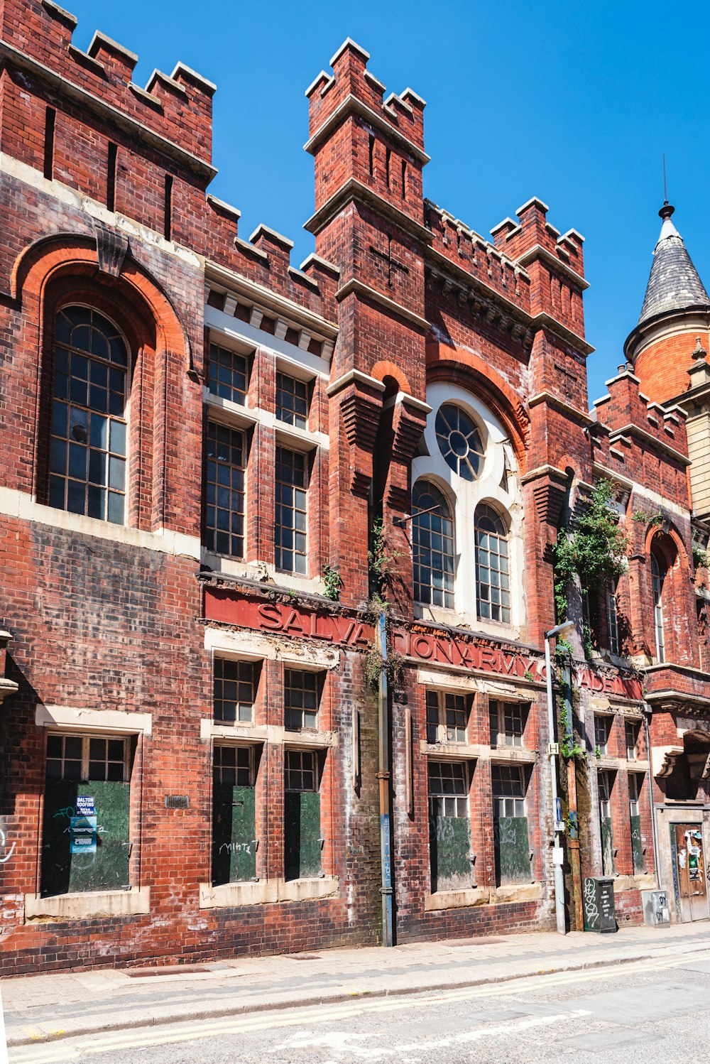 brown brick building with green plants on the side