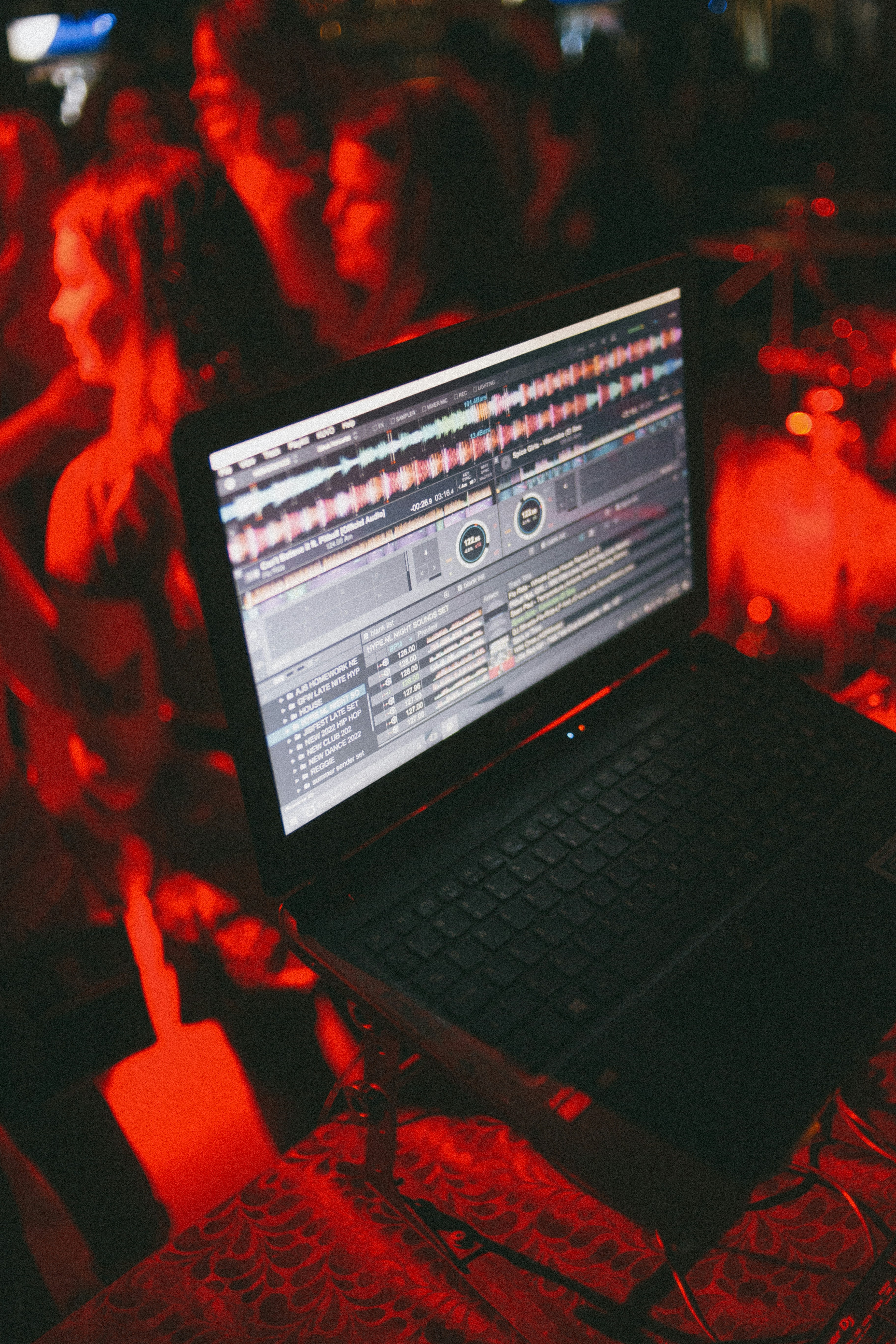 black laptop computer turned on on red textile