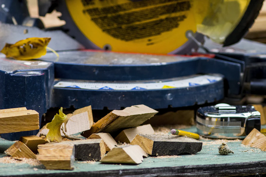 Miter saw with cut wood pieces, measuring tape and pencil for trim work