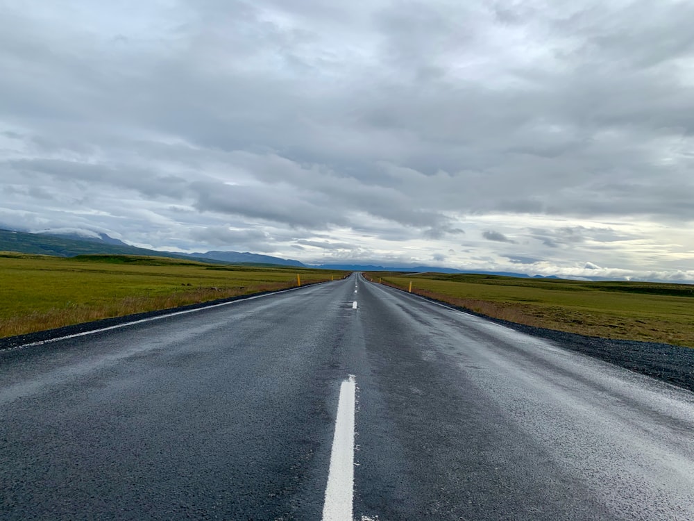 gray asphalt road under cloudy sky during daytime