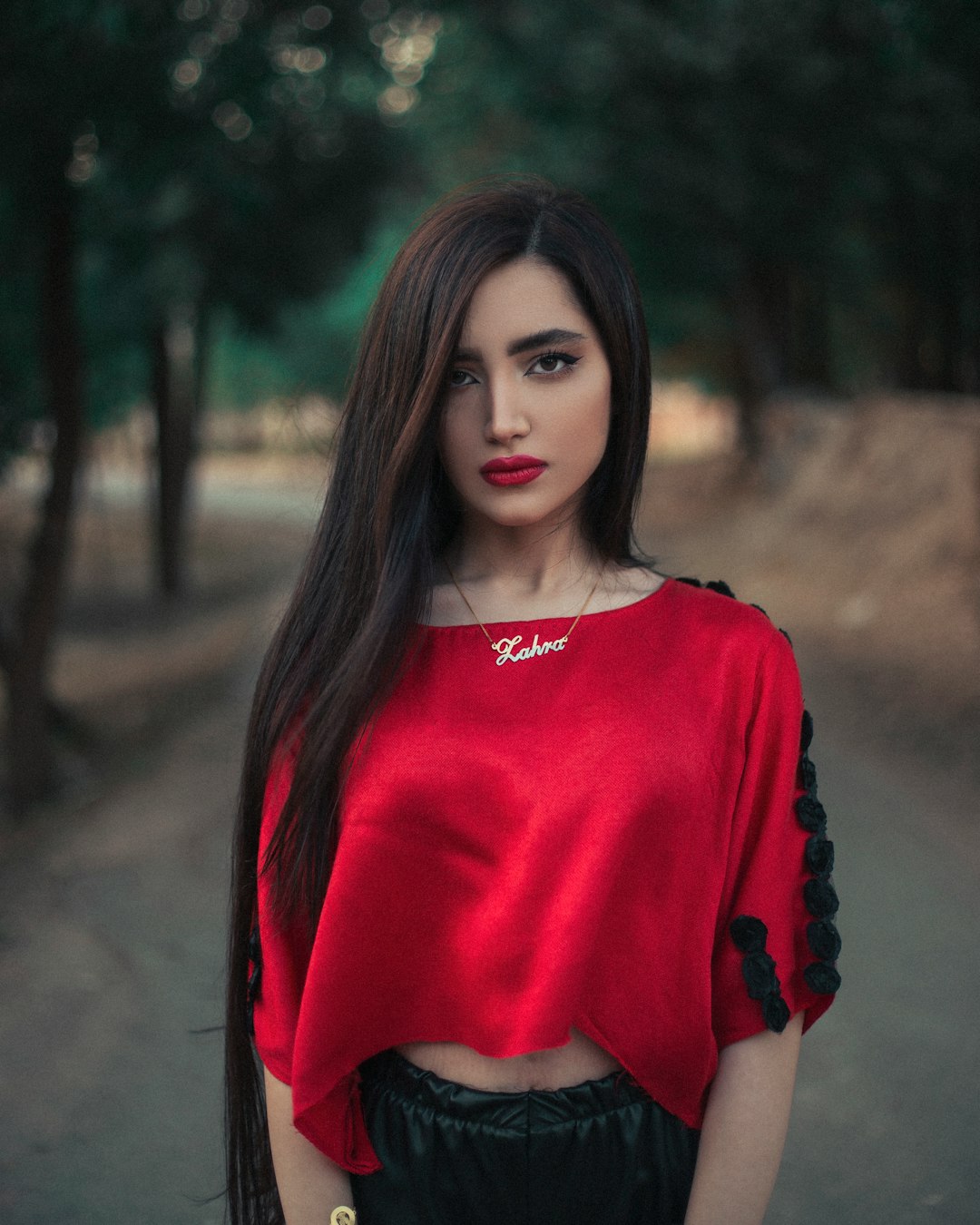 woman in red crew neck long sleeve shirt standing in forest during daytime