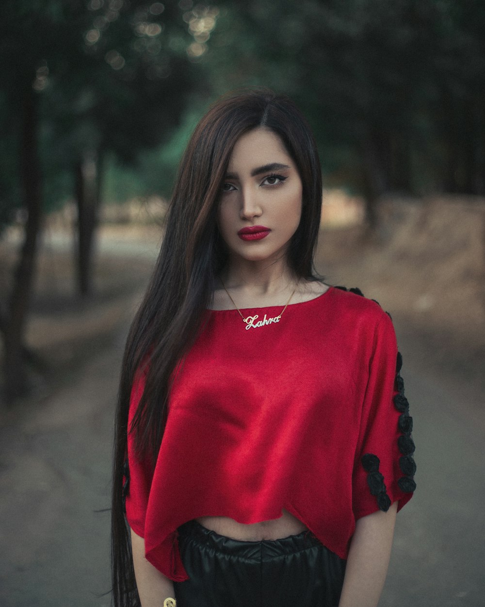 woman in red crew neck long sleeve shirt standing in forest during daytime