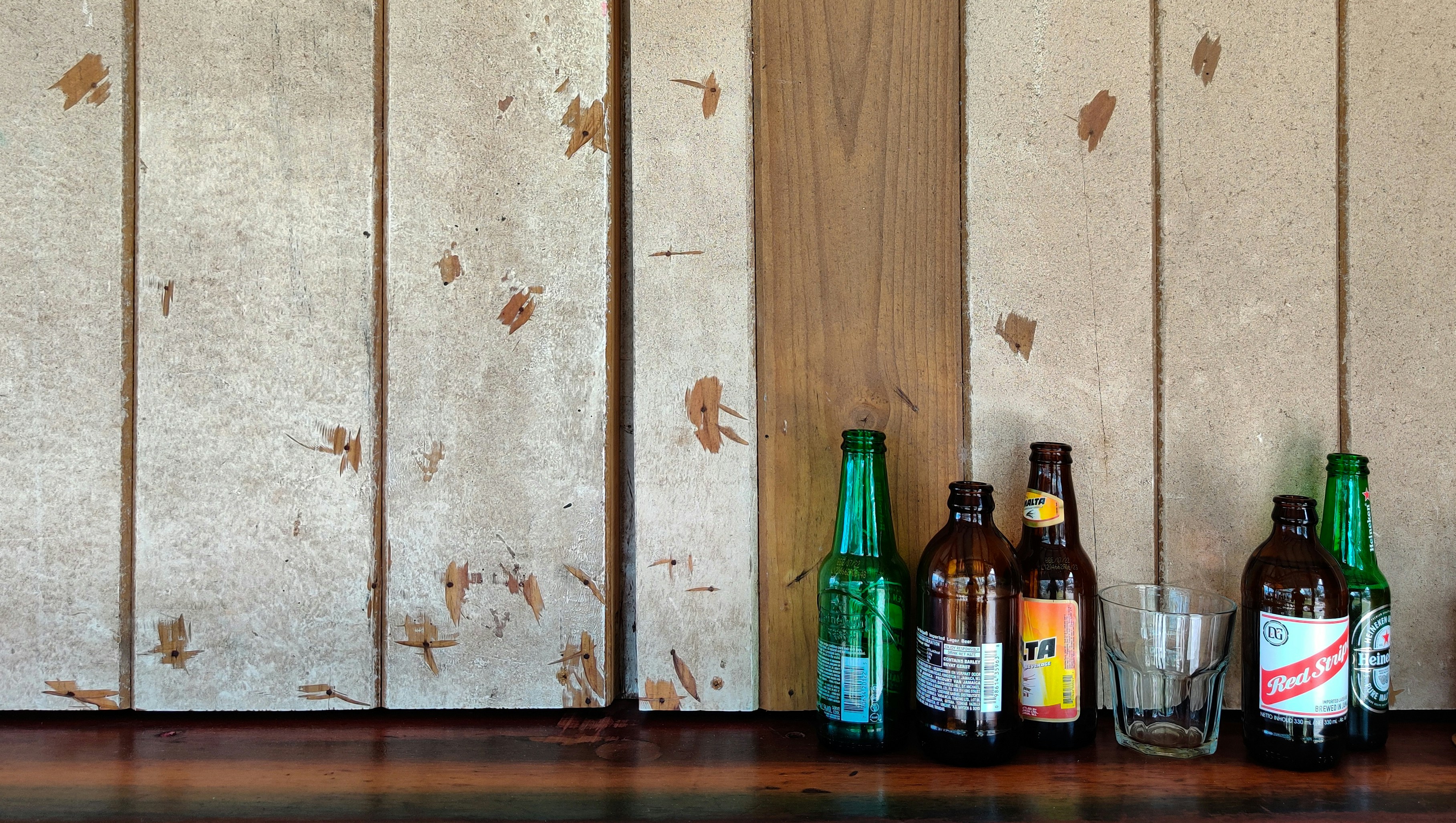 green glass bottles on brown wooden table