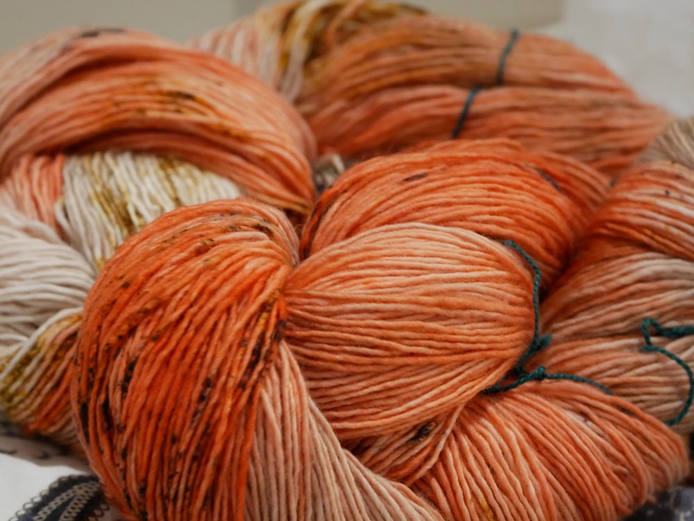 orange yarn on white surface