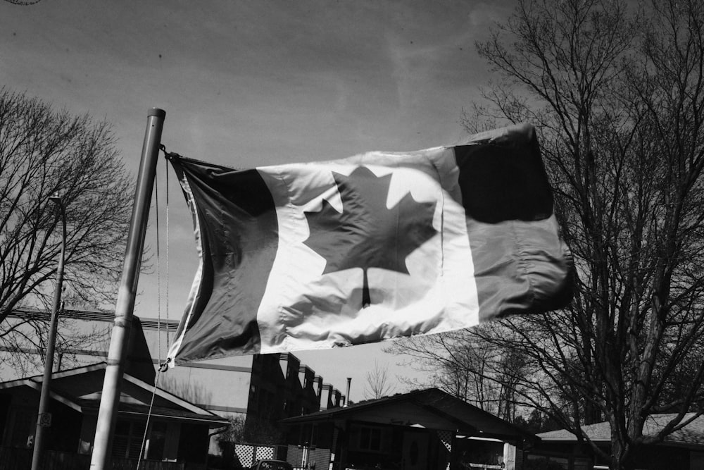 grayscale photo of flag of us a on pole