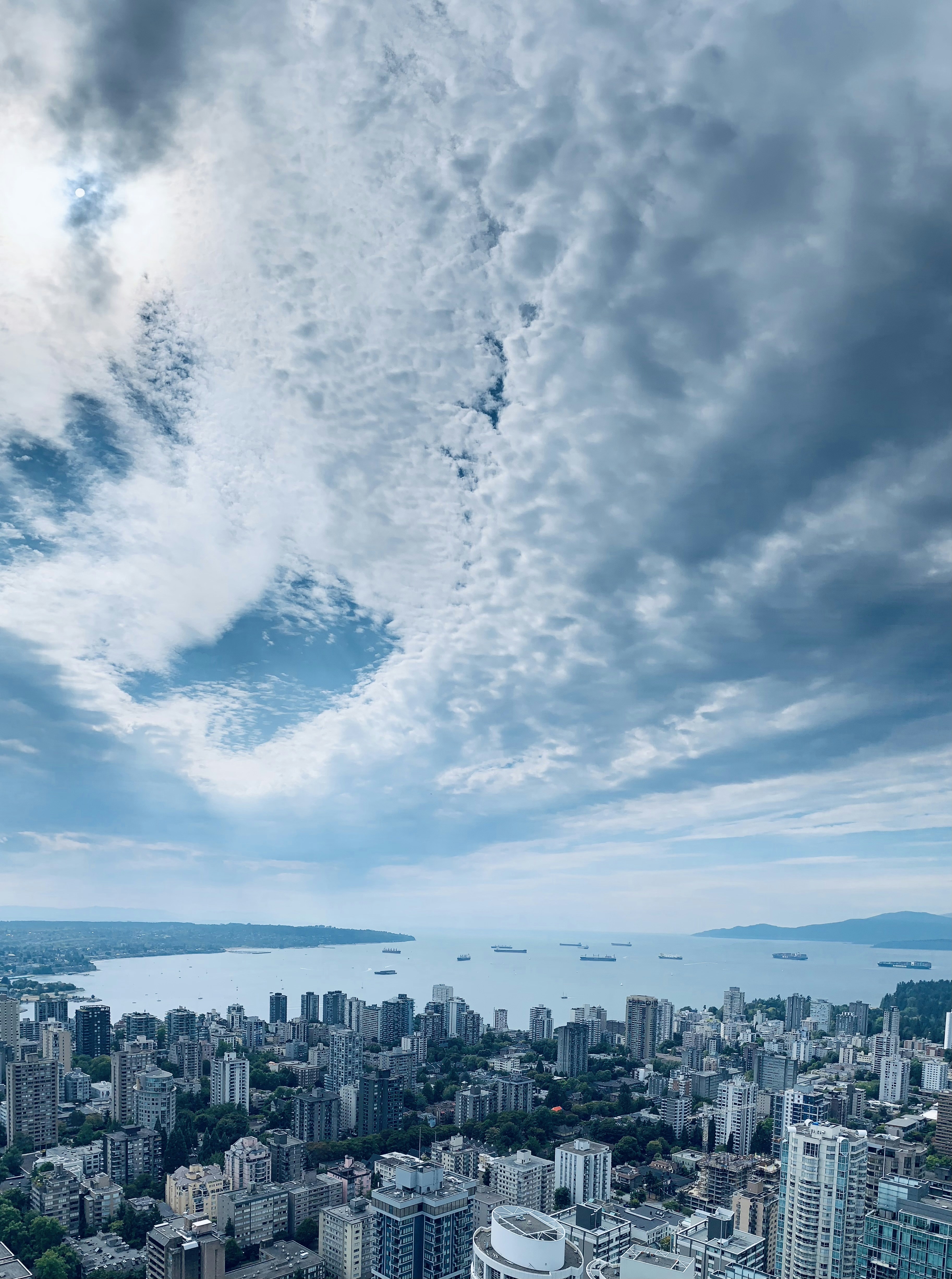 city skyline under white clouds and blue sky during daytime