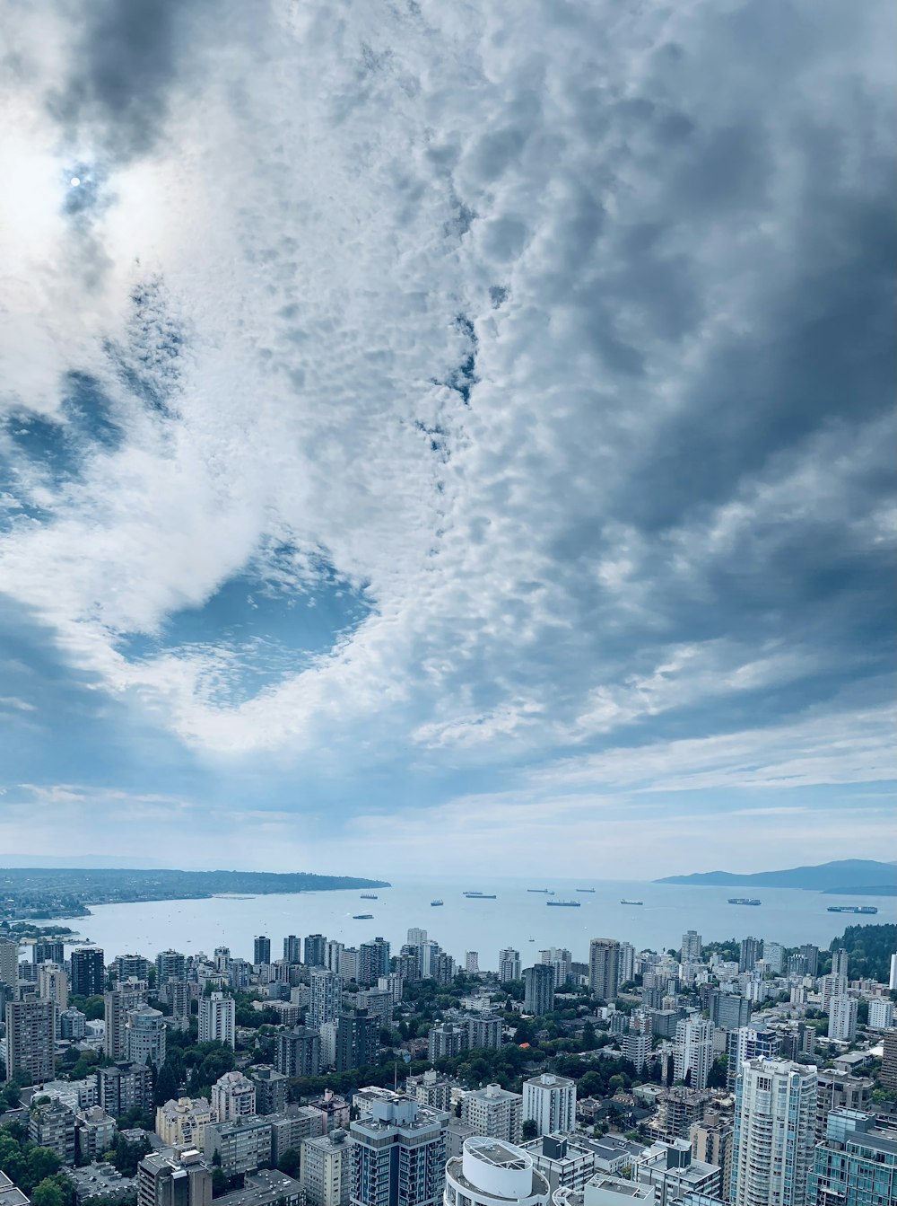 city skyline under white clouds and blue sky during daytime