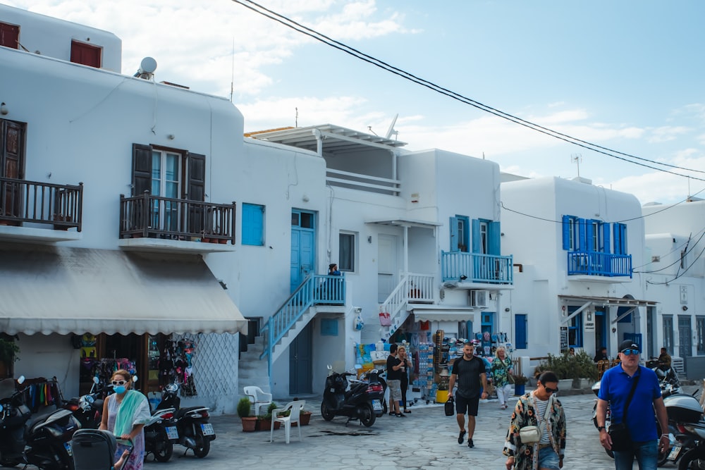 people walking on street near white and blue concrete building during daytime