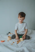 boy in white crew neck t-shirt sitting on bed