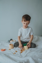 boy in white crew neck t-shirt sitting on bed