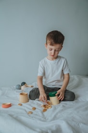 boy in white crew neck t-shirt sitting on bed