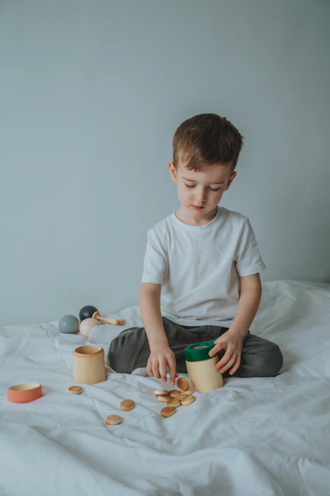 boy in white crew neck t-shirt sitting on bed
