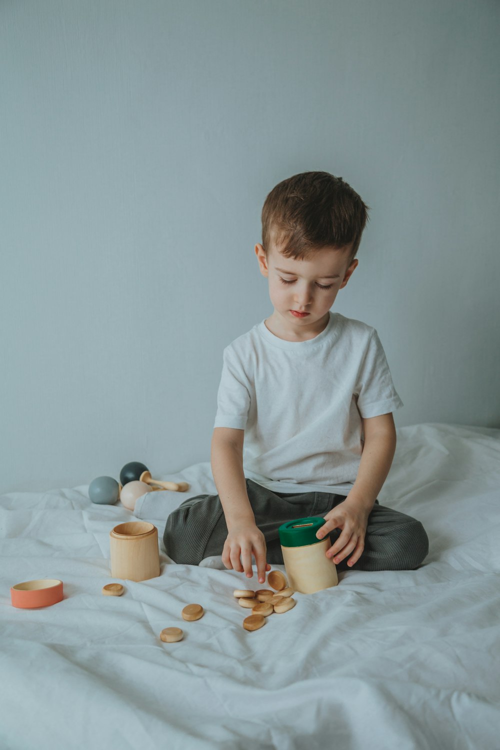 boy in white crew neck t-shirt sitting on bed