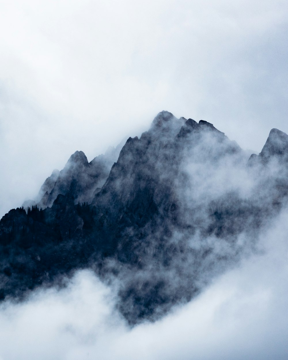 black mountain covered by clouds