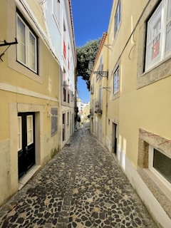 An ancient cobblestone alleyway lined with charming old buildings and flowering balconies.