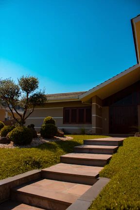 Modern house exterior with a well-manicured garden under a clear blue sky
