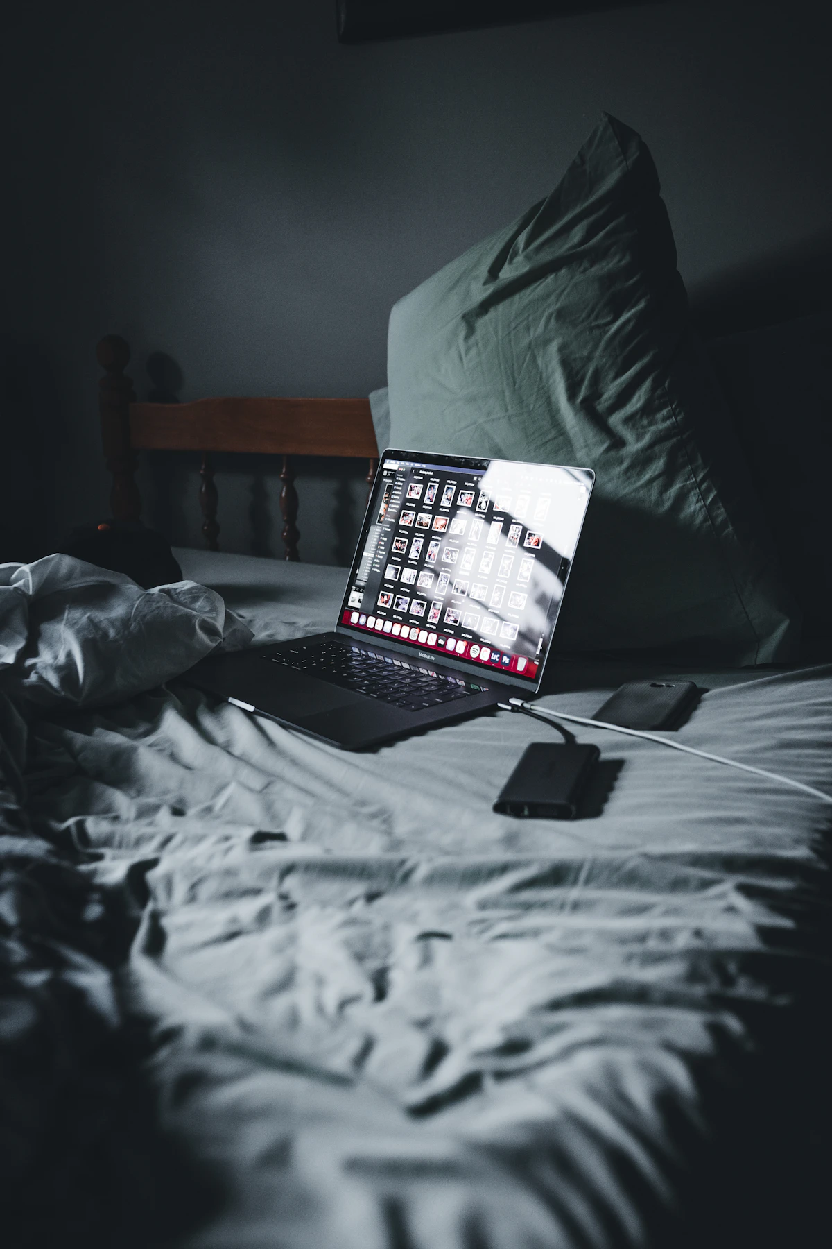 A laptop on a bed beside a smartphone