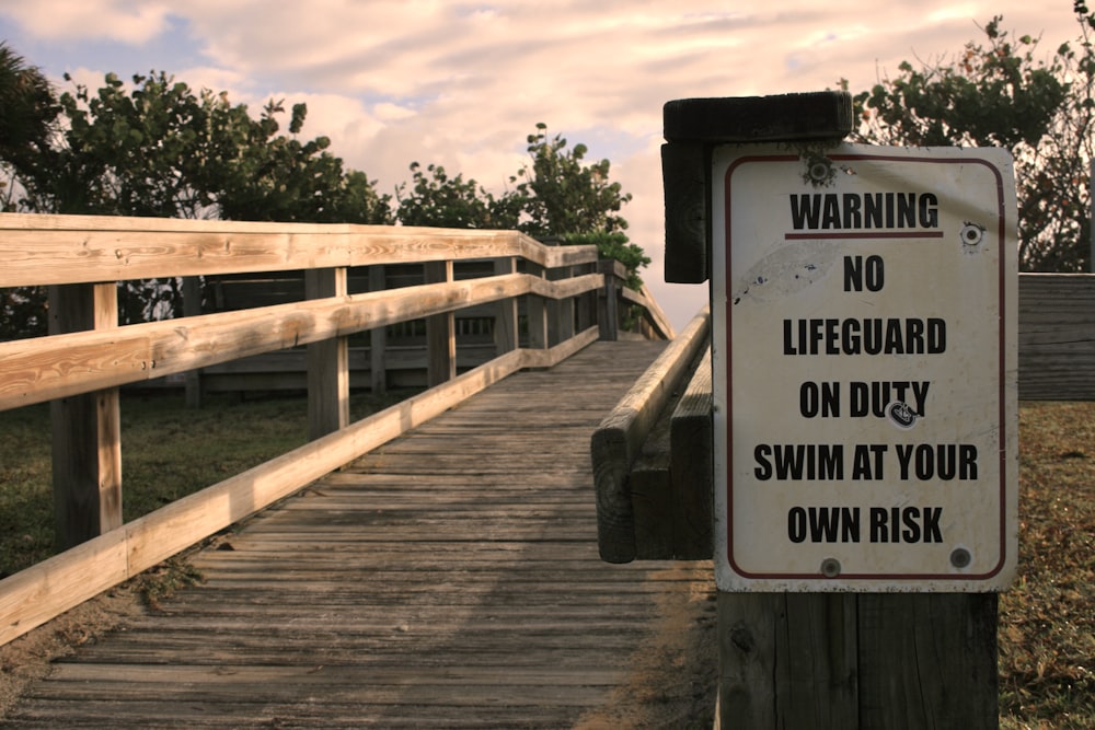 brown wooden bridge with white and black wooden signage