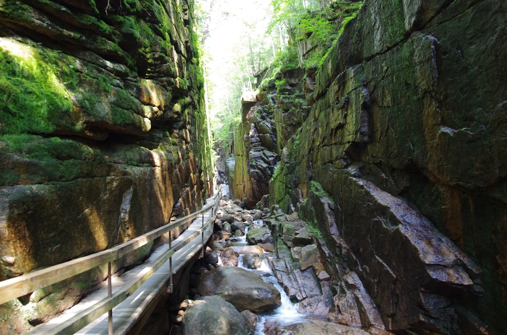 brown wooden bridge on rocky mountain