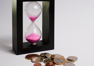 clear hour glass with coins