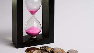 clear hour glass with coins