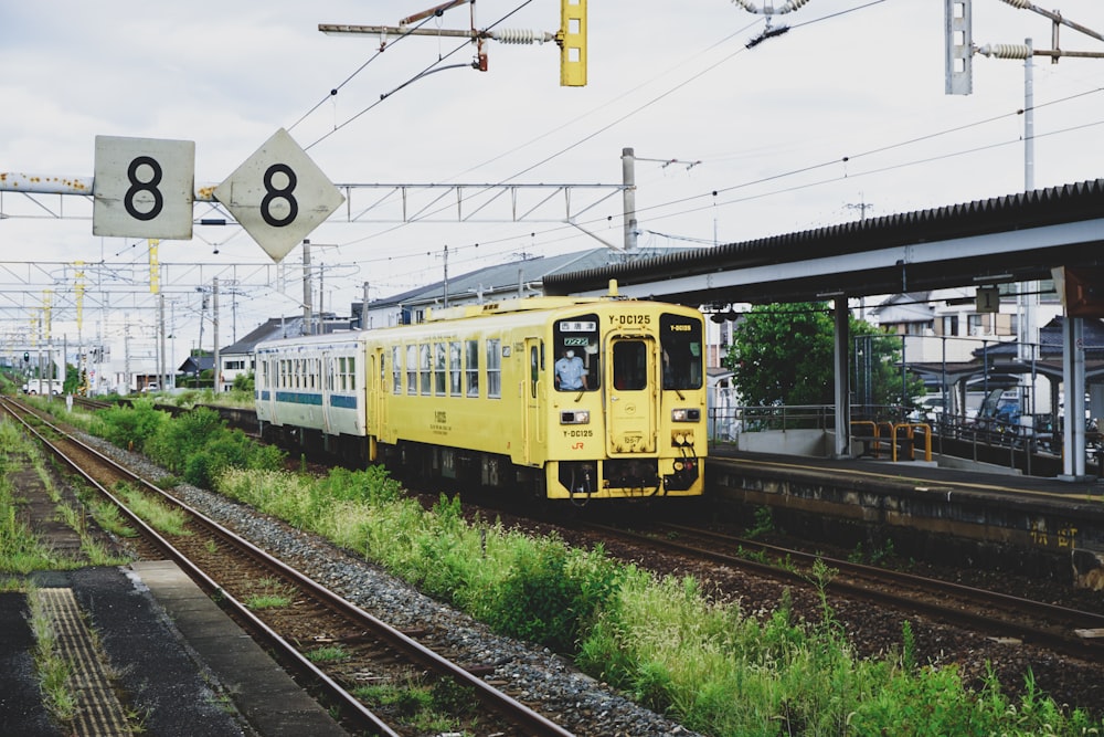 yellow and white train on rail tracks