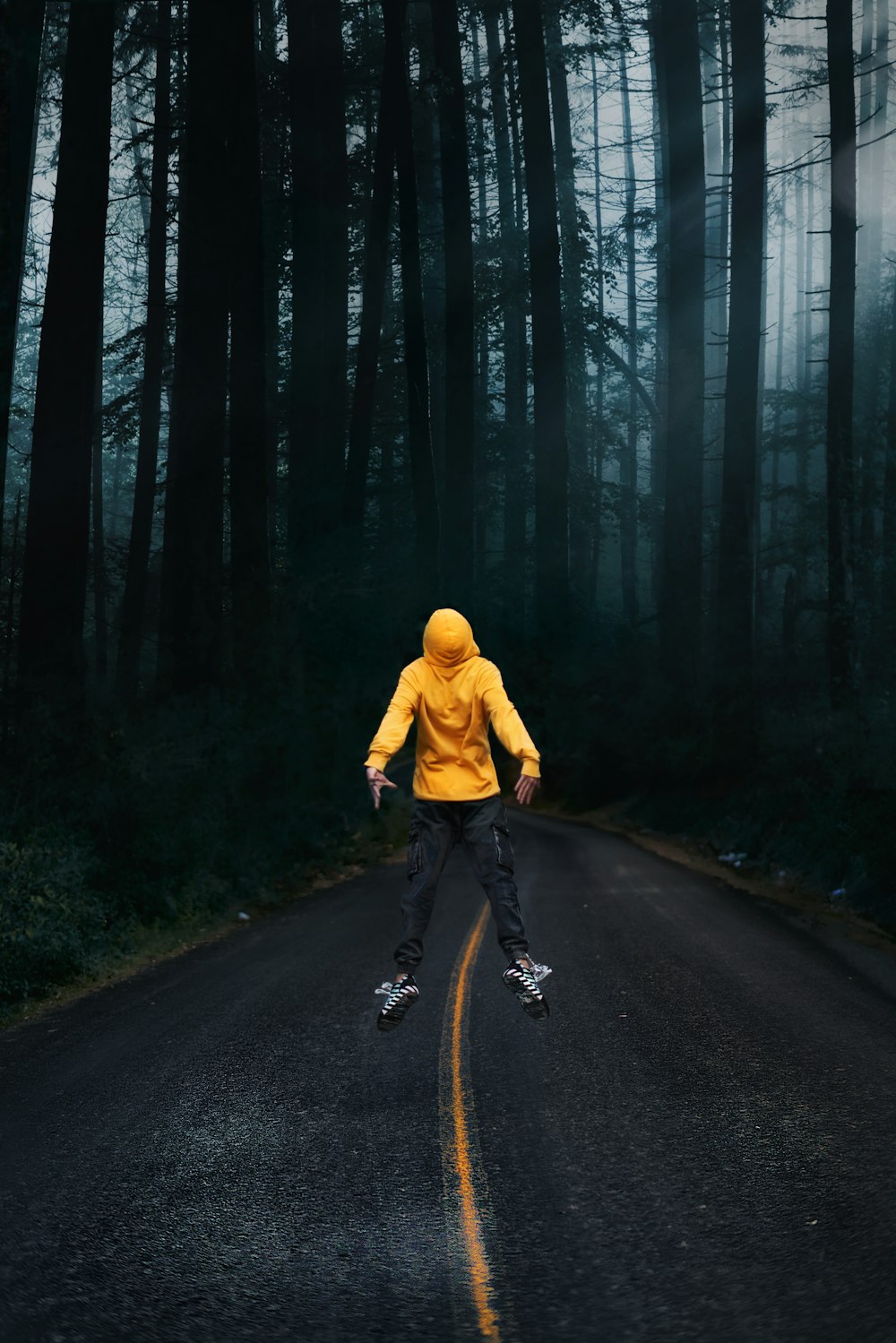 man in yellow hoodie and black pants riding bicycle on road during daytime