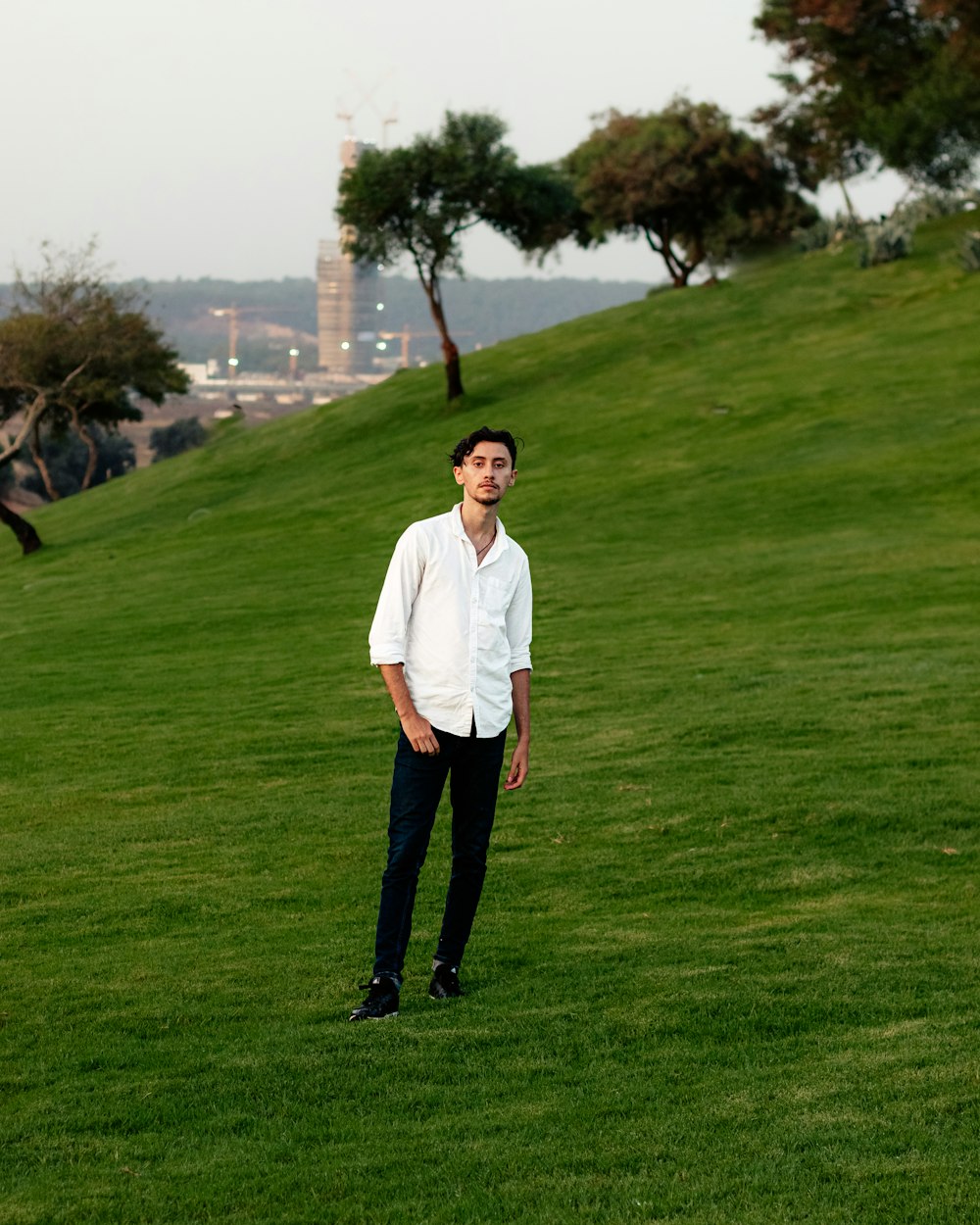 man in white polo shirt standing on green grass field during daytime