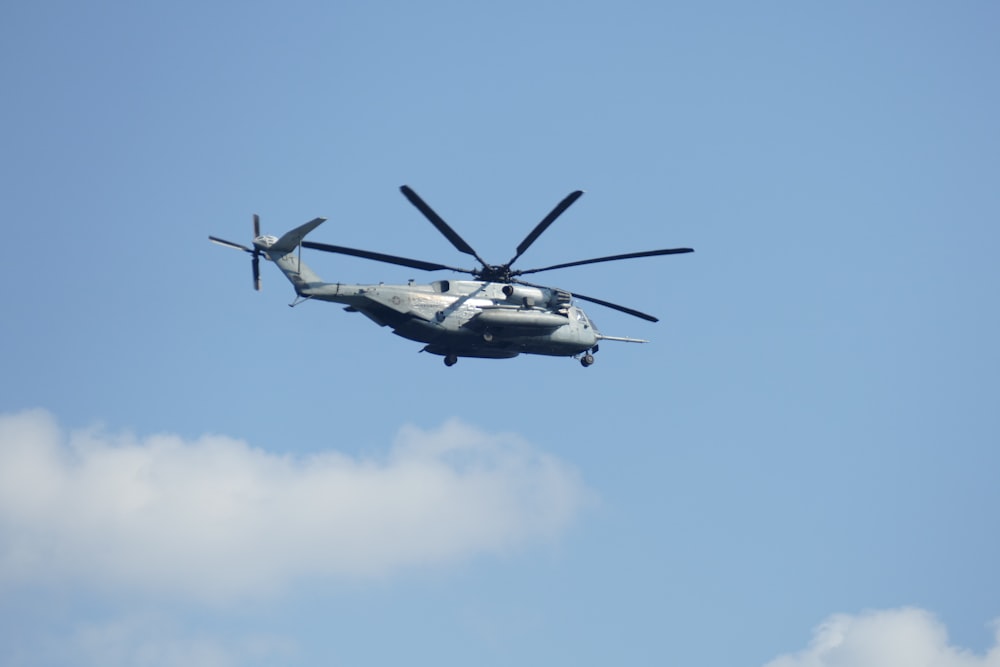 elicottero bianco e nero che vola nel cielo durante il giorno