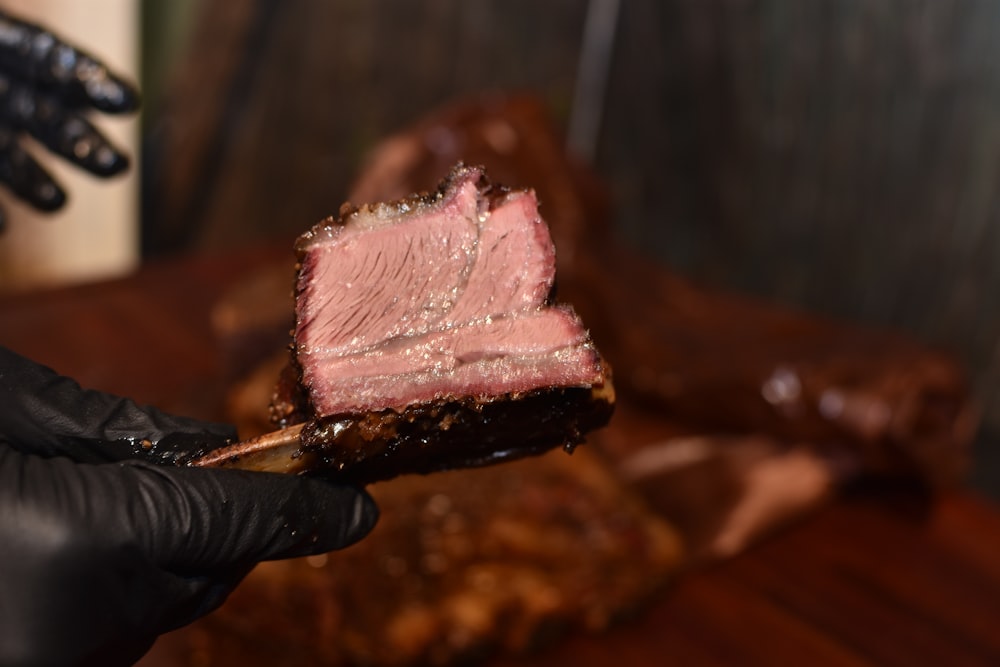 person holding grilled meat during daytime