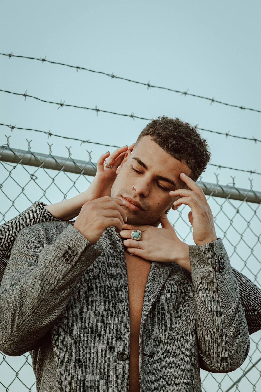 man in gray coat holding his face