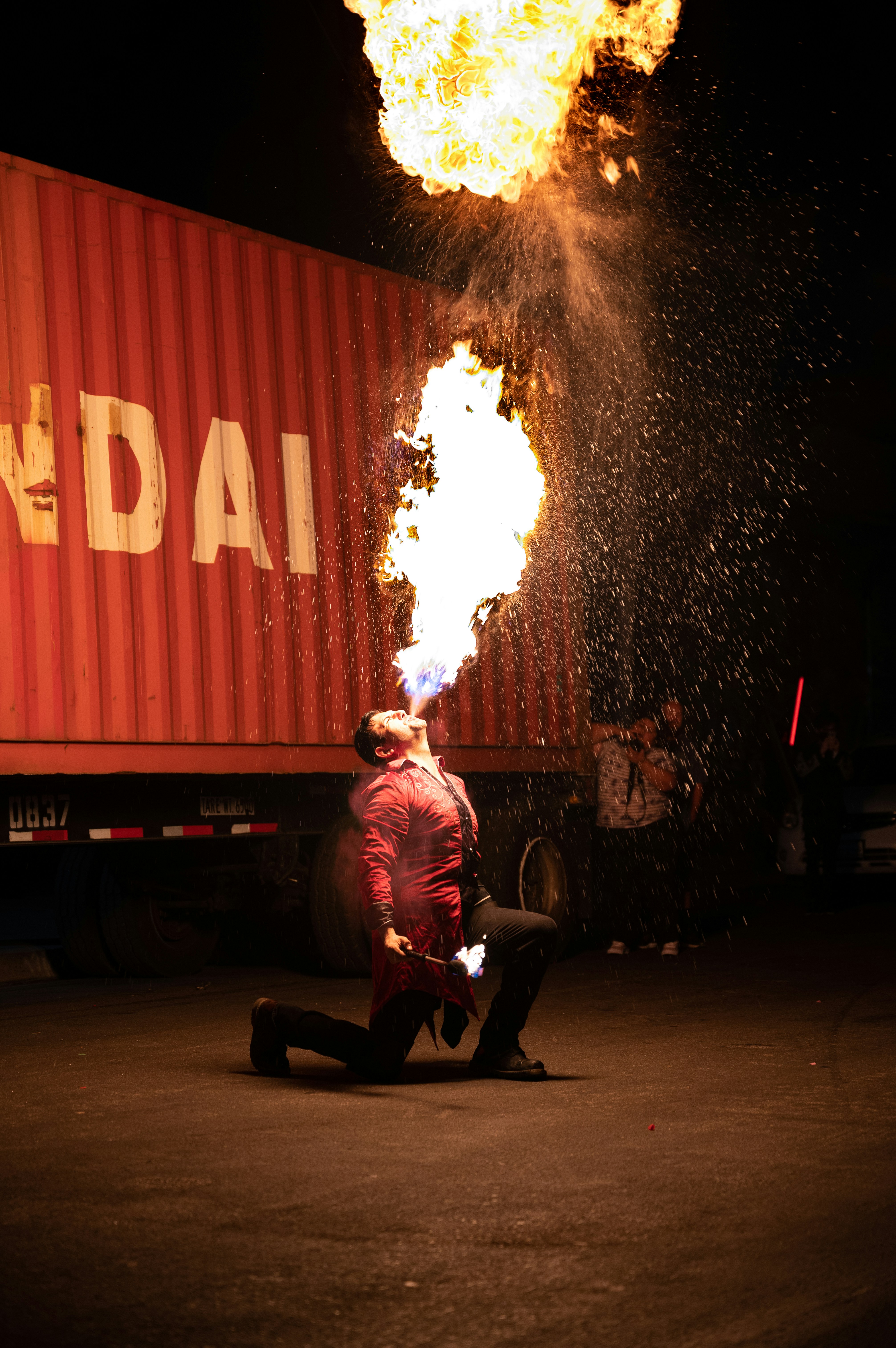 Homme en chemise rouge assis sur une chaise noire près du feu