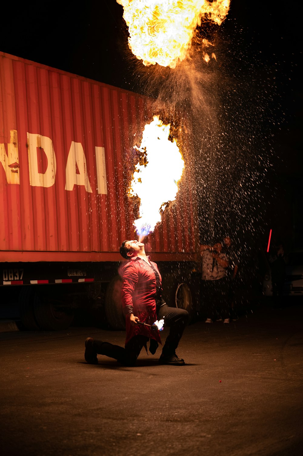 man in red shirt sitting on black chair near fire