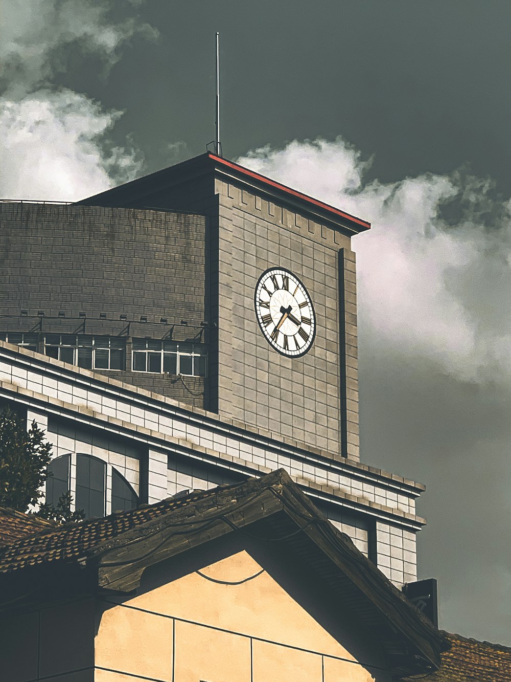 a clock on the side of a building on a cloudy day