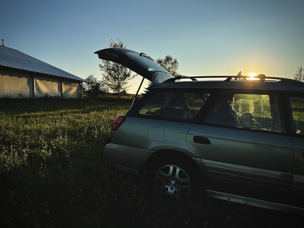 gray suv parked on green grass field during daytime