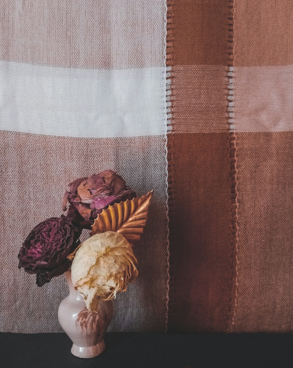 white ceramic figurine on brown and white plaid textile