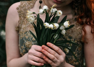 woman in green dress holding white flower bouquet