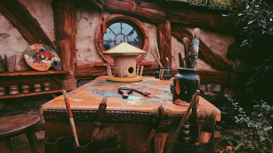 A rustic wooden table displaying moo treat cups and paint kits with farm scenery in the background.