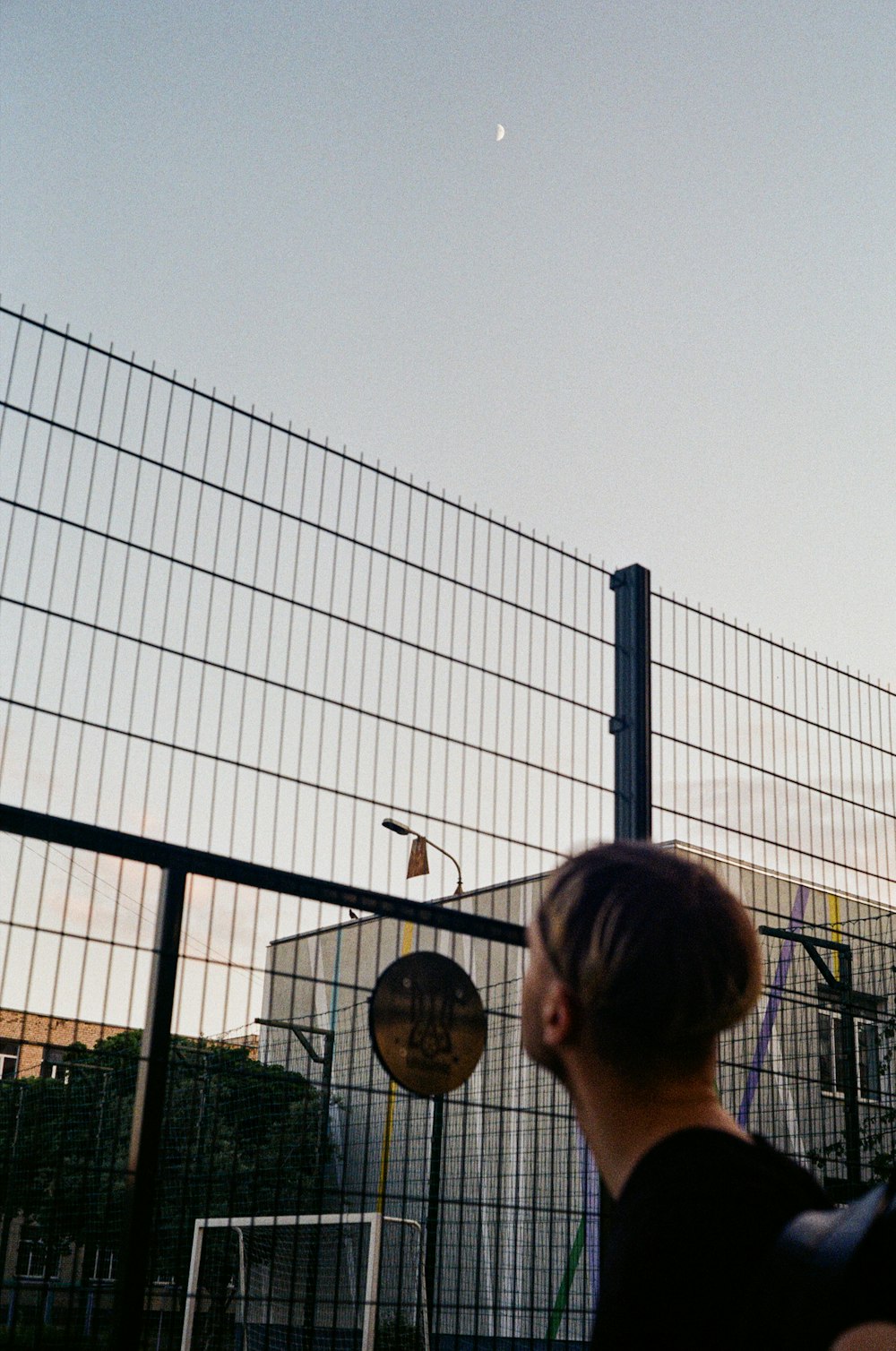 woman in black shirt standing near black metal fence during daytime