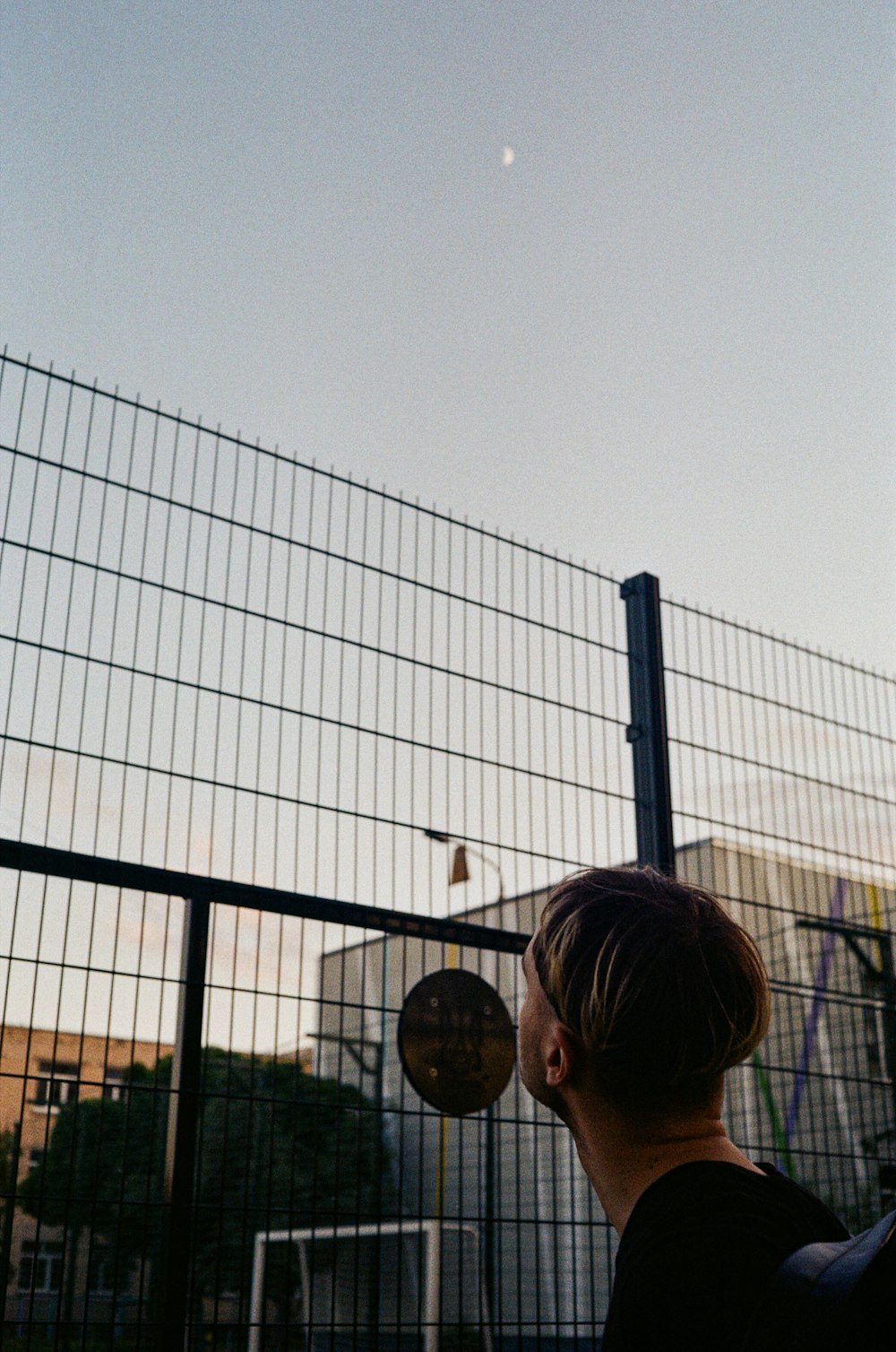 woman in black shirt standing near fence during daytime