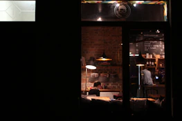A small business owner happily using a laptop in a cozy coffee shop.