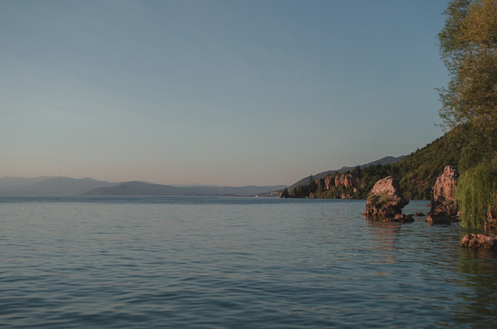 body of water near mountain during daytime