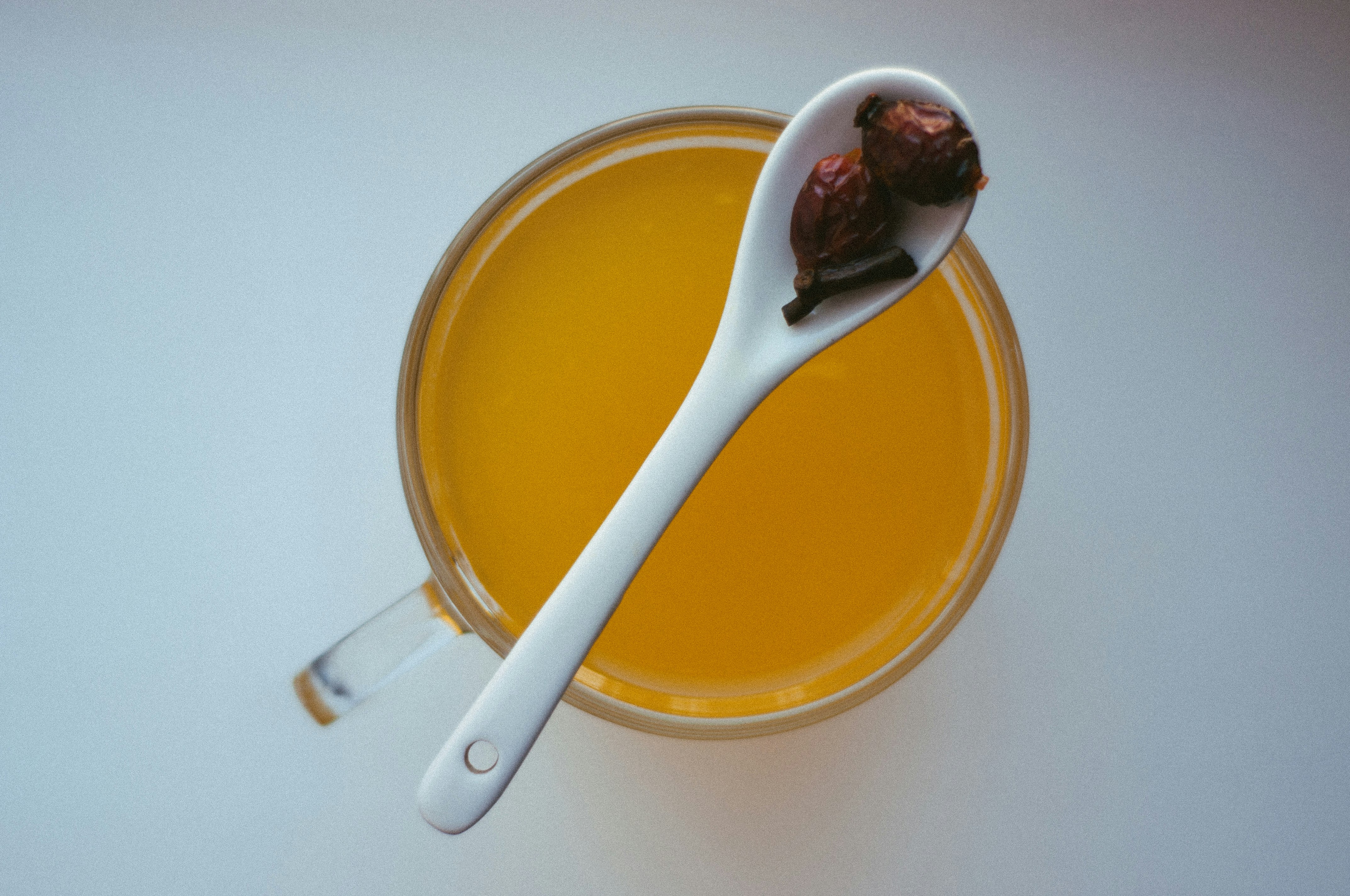 yellow liquid in clear glass mug with spoon