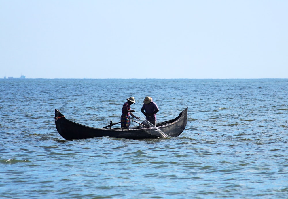 2 men riding on boat during daytime