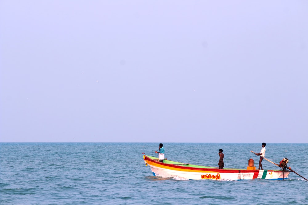 2 personas montando en barco rojo y blanco en el mar durante el día