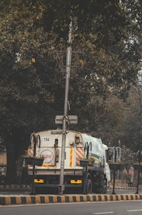 A large dumpster truck parked outside a residential home.