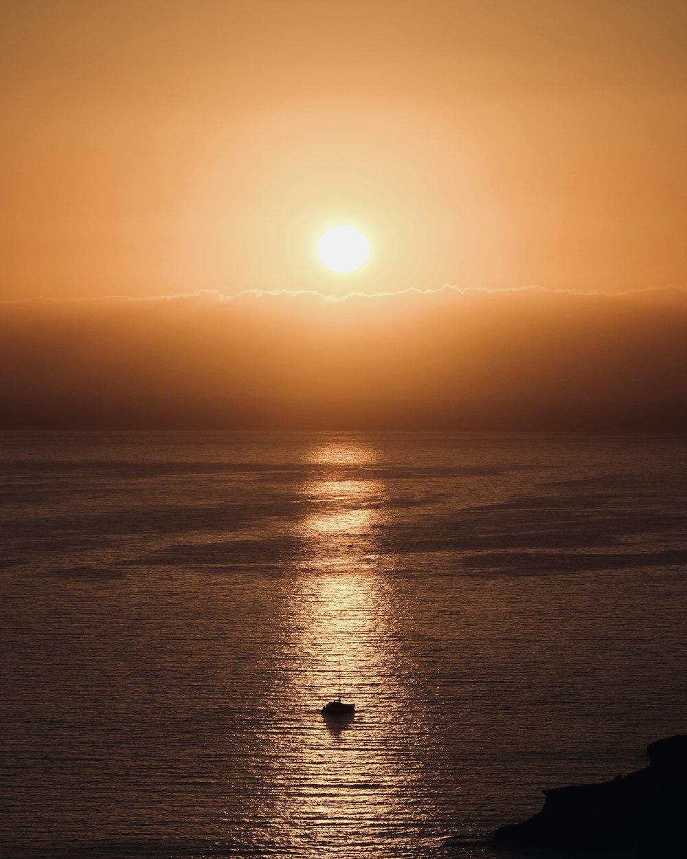 silhouette of boat on sea during sunset