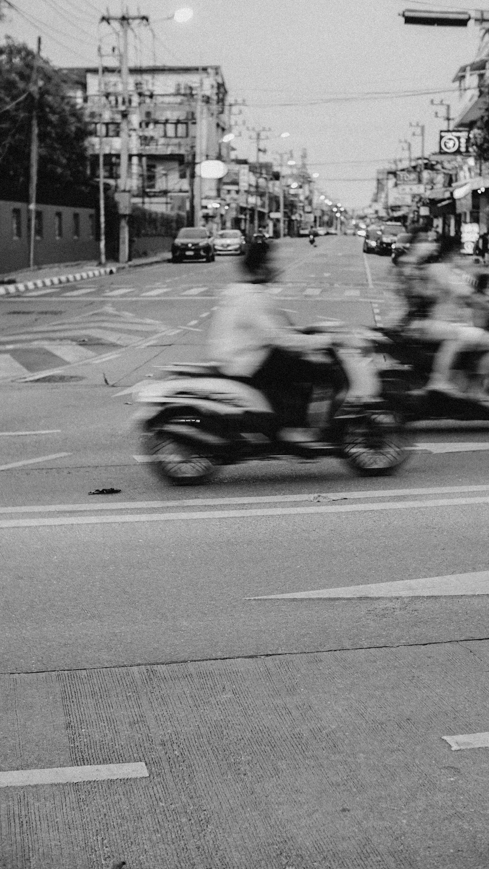 grayscale photo of people riding motorcycle on road